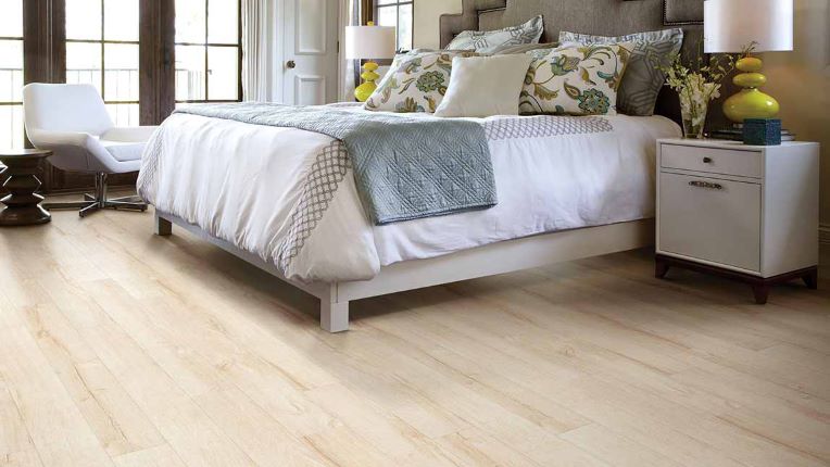 beautiful wood look laminate flooring in a bright and airy bedroom